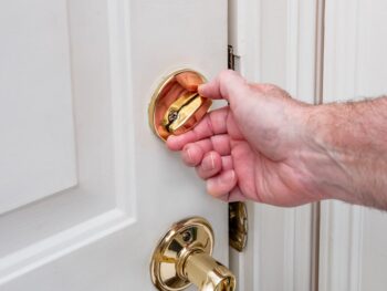 Golden Deadbolt On A White Door